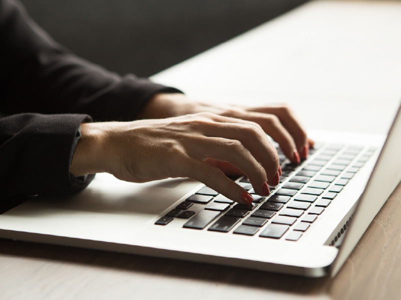 Se ven dos manos escribiendo en un computador
