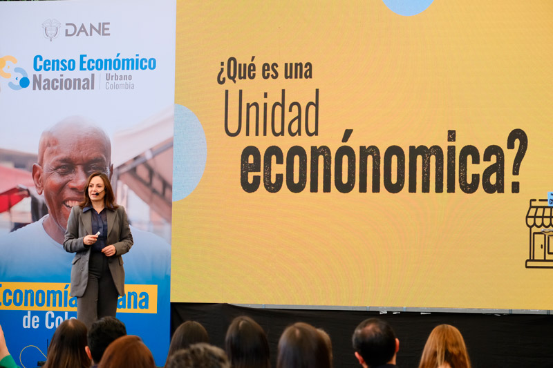 Piedad Urdinola, Directora del Departamento Administrativo Nacional de Estadística (DANE) presentando, con una pantalla a su derecha que pregunta '¿Qué es una Unidad económica?' y un banner a su izquierda sobre el Censo Económico Urbano del DANE