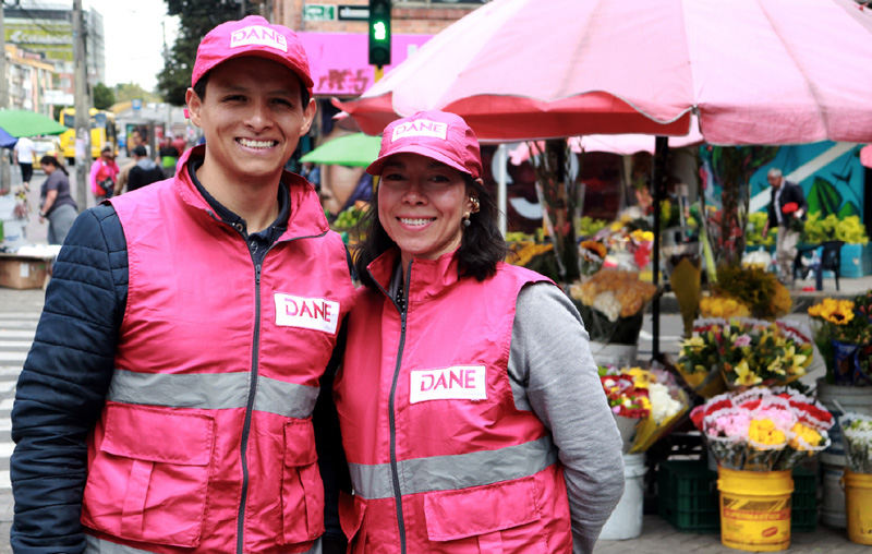 Dos encuestadores (hombre y mujer) sonriéndole a la cámara
